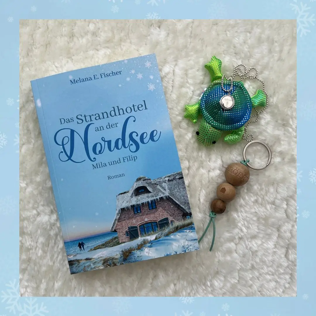22.02.2024: Taschenbuch der Reihe: Das Strandhotel an der Nordsee Mila und Filip band 1 Bild von der Taschenbuchausgabe für Das Strandhotel an der Nordsee Mila und Filip - blauer Rahmen,
auf einem Teppich liegend das Taschenbuch und daneben die kleine Schildkröte von Hanna und ein Anhänger mit 3 Holzkugeln (Zimmerschlüssel)
